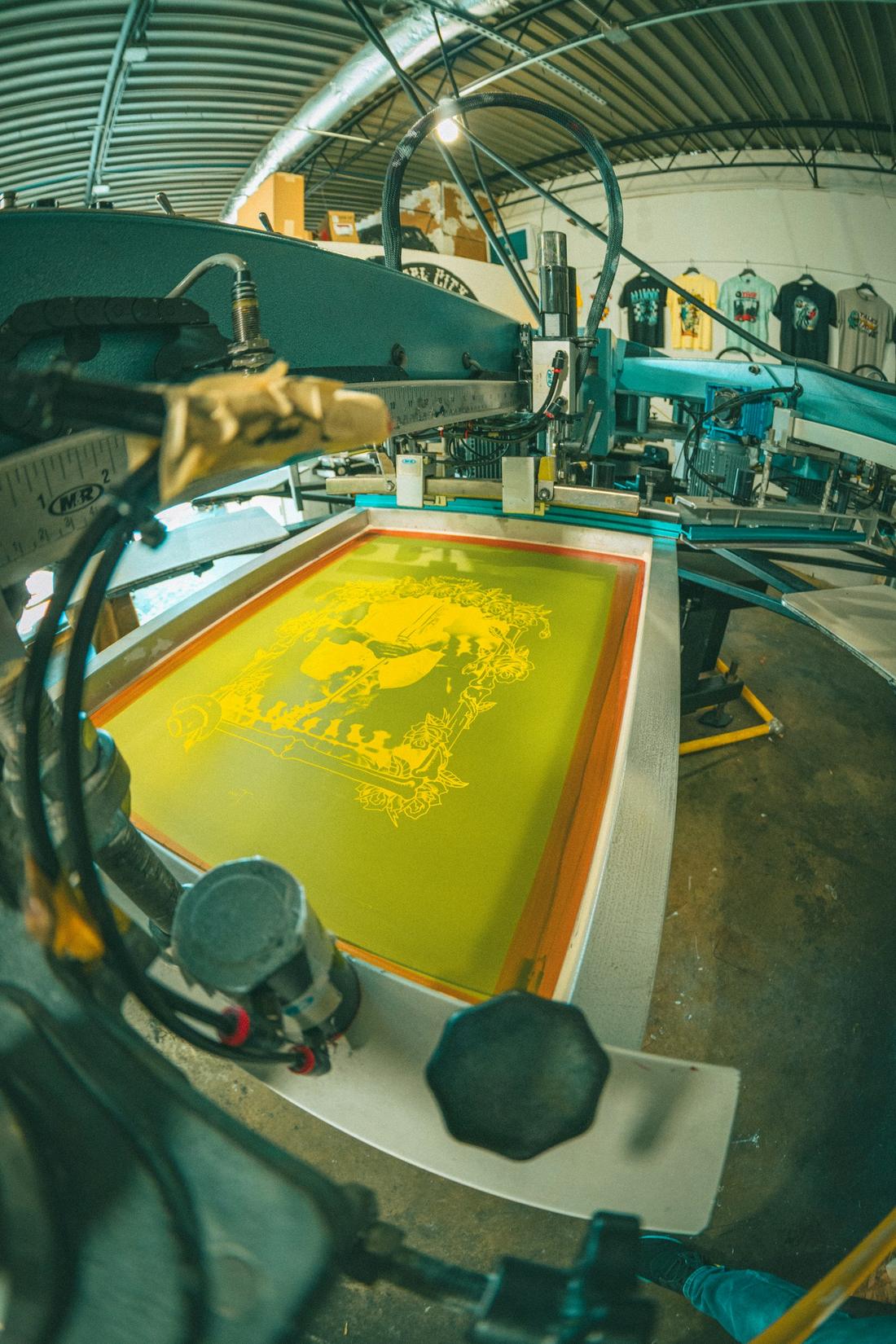 Yellow ink on a screen locked into an automatic press